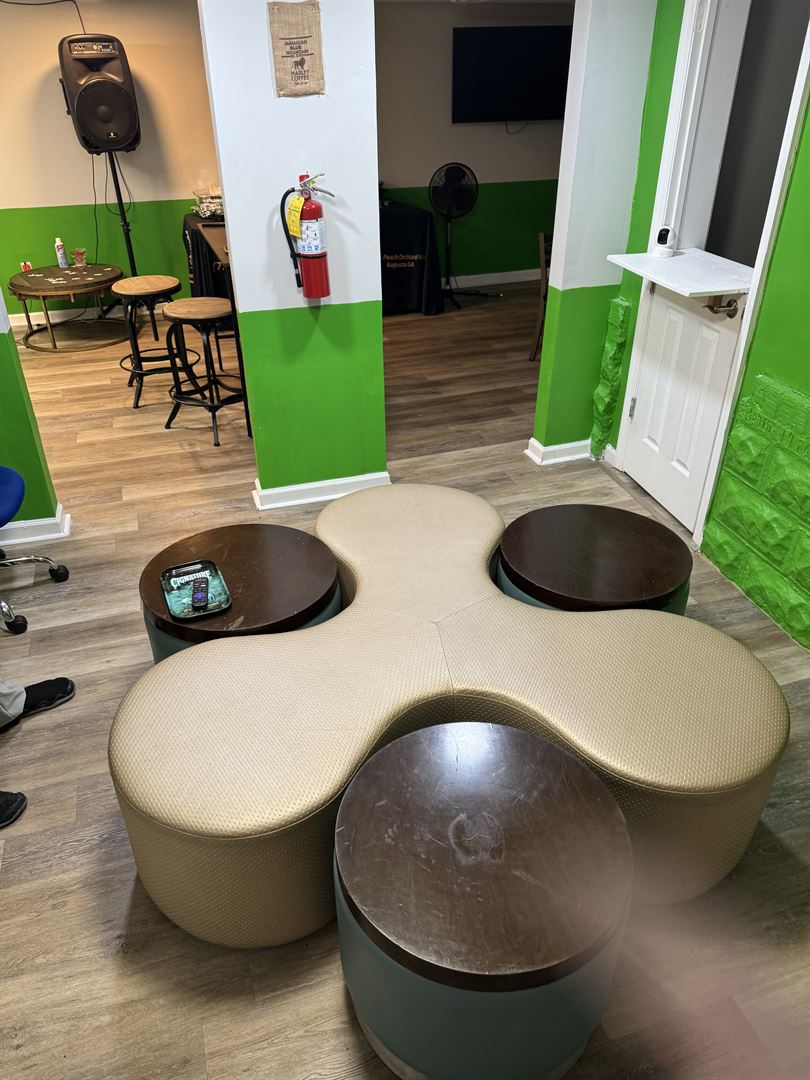 The Exotic Smoker Vape and Smoke Shop - Rental Venue - seating in a green and white building with wood flooring